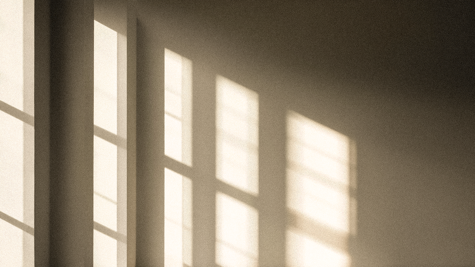 Sunlight filtering through window panes onto a wall